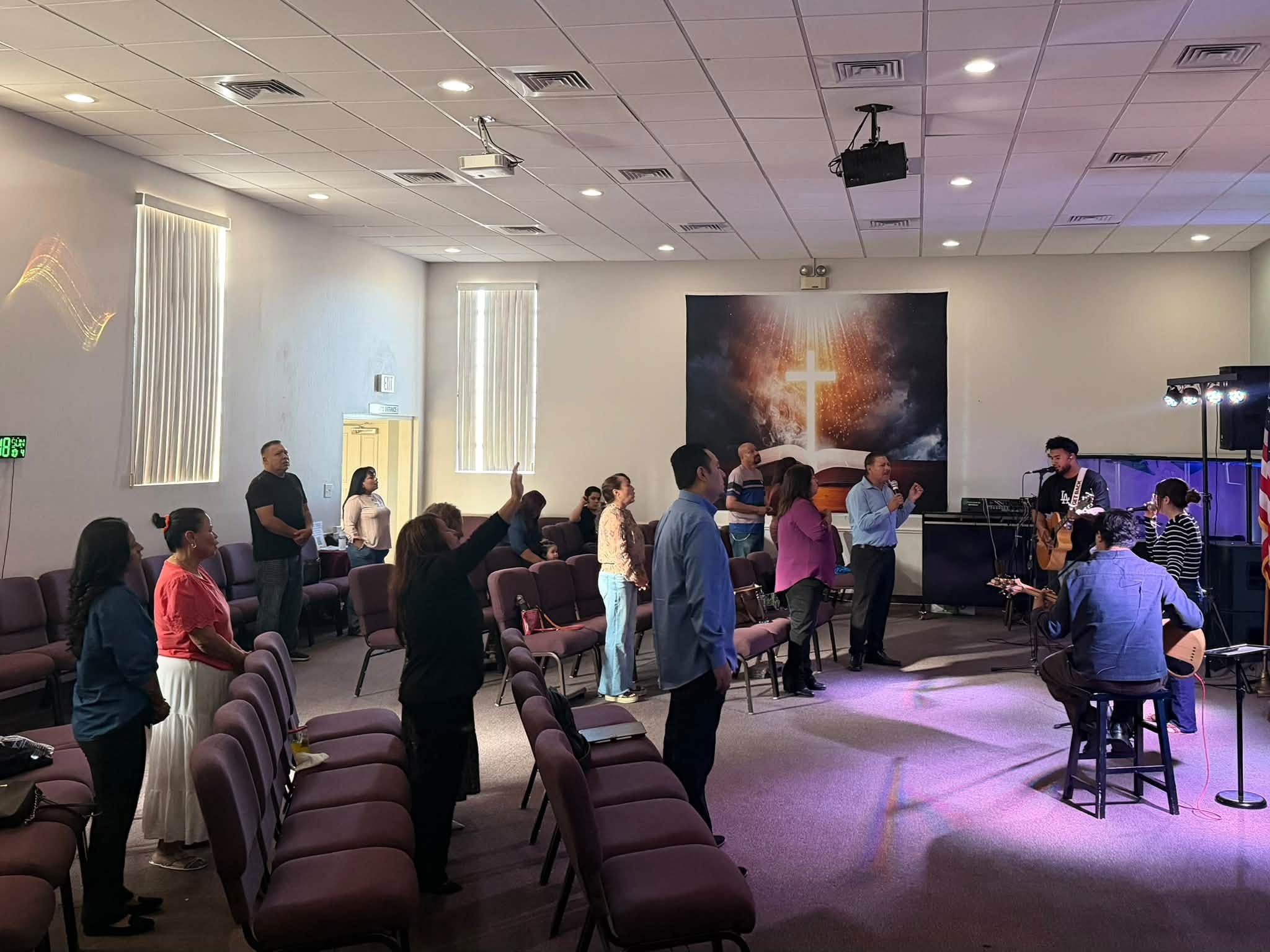 La iglesia adorando a Dios un domingo, con el equipo de alabanza al frente